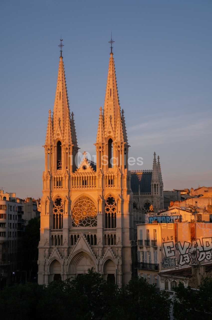 Façade de la basilique Notre-Dame-de-la-Garde illuminée au coucher de soleil, vue depuis Marseille.