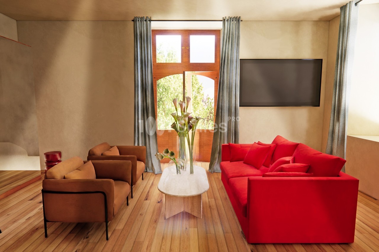 Salon lumineux avec canapé rouge, fauteuils marron, table basse blanche, télévision murale et grandes fenêtres avec rideaux…