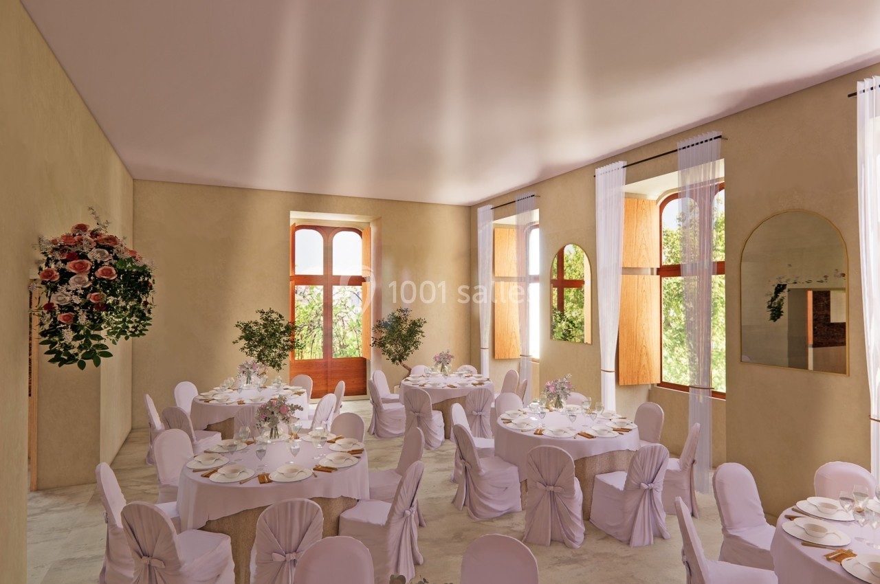 Salle lumineuse décorée pour un événement, avec des tables rondes dressées, des chaises blanches et des fleurs.
