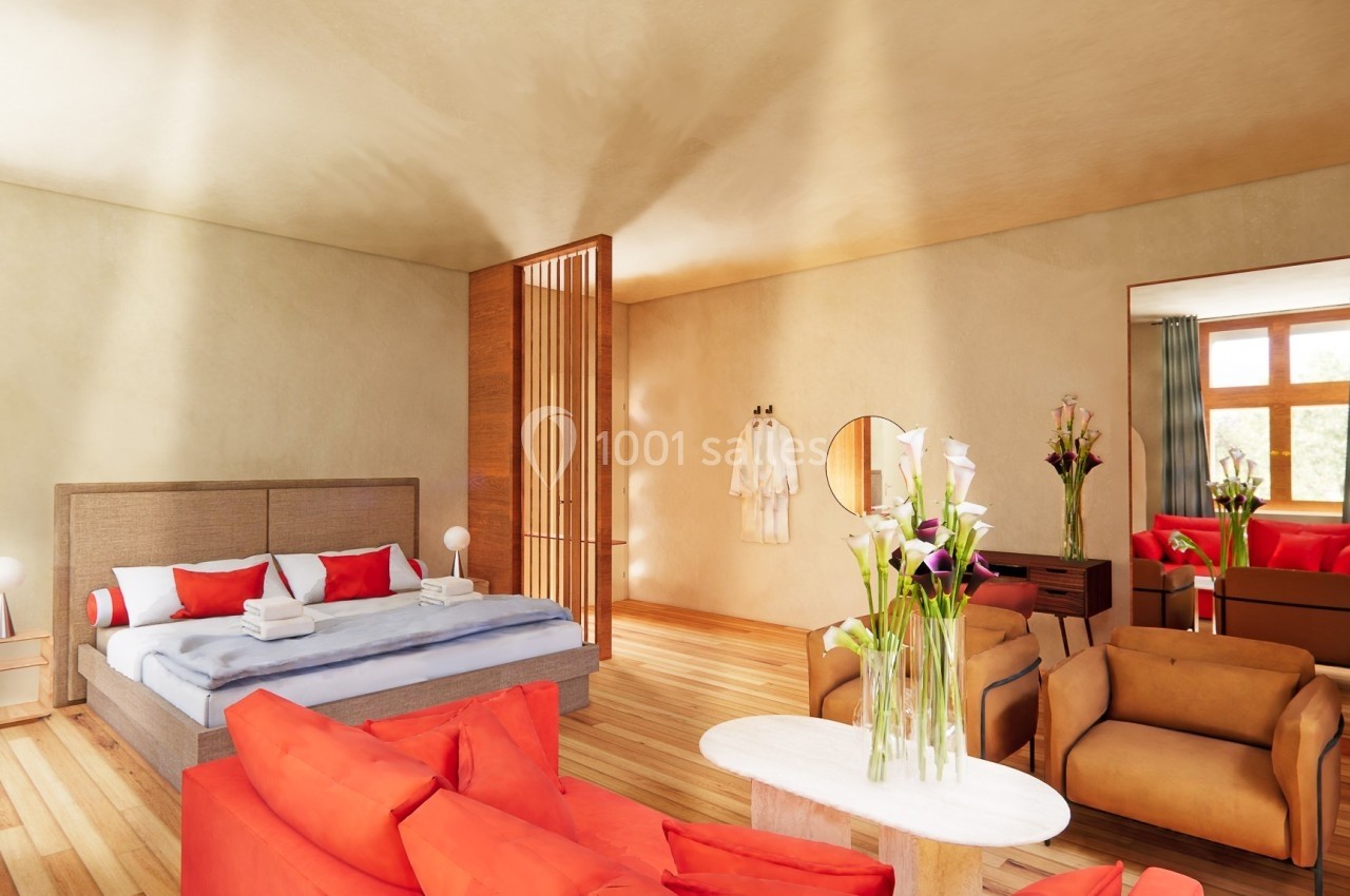 Chambre lumineuse avec lit double, canapé rouge, fauteuils, table basse et décoration florale dans un style moderne.