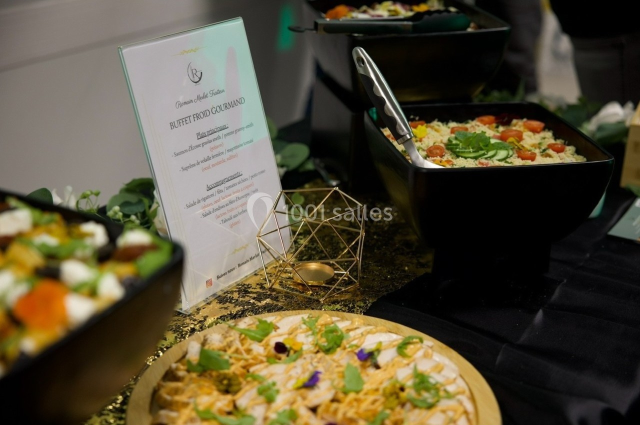 Buffet avec plats variés, incluant salades et tartes, présenté sur une table décorée avec des éléments dorés.