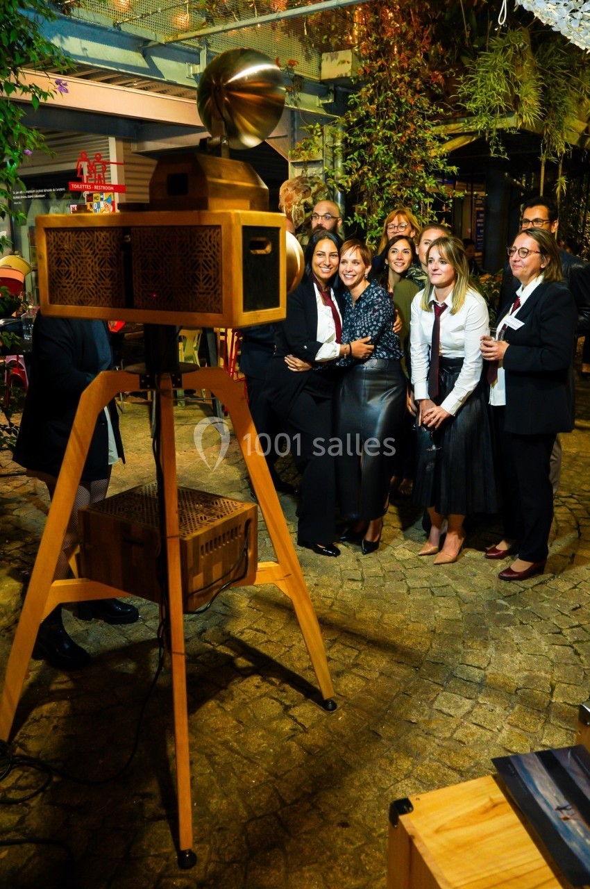 Un groupe de personnes posant pour une photo devant un projecteur vintage dans un cadre extérieur convivial.