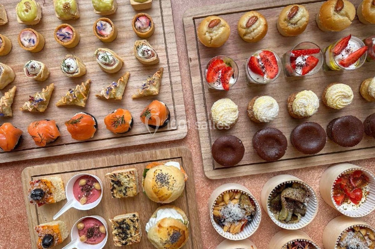 Plateaux en bois garnis de bouchées salées et sucrées variées, présentées pour un buffet ou un apéritif.