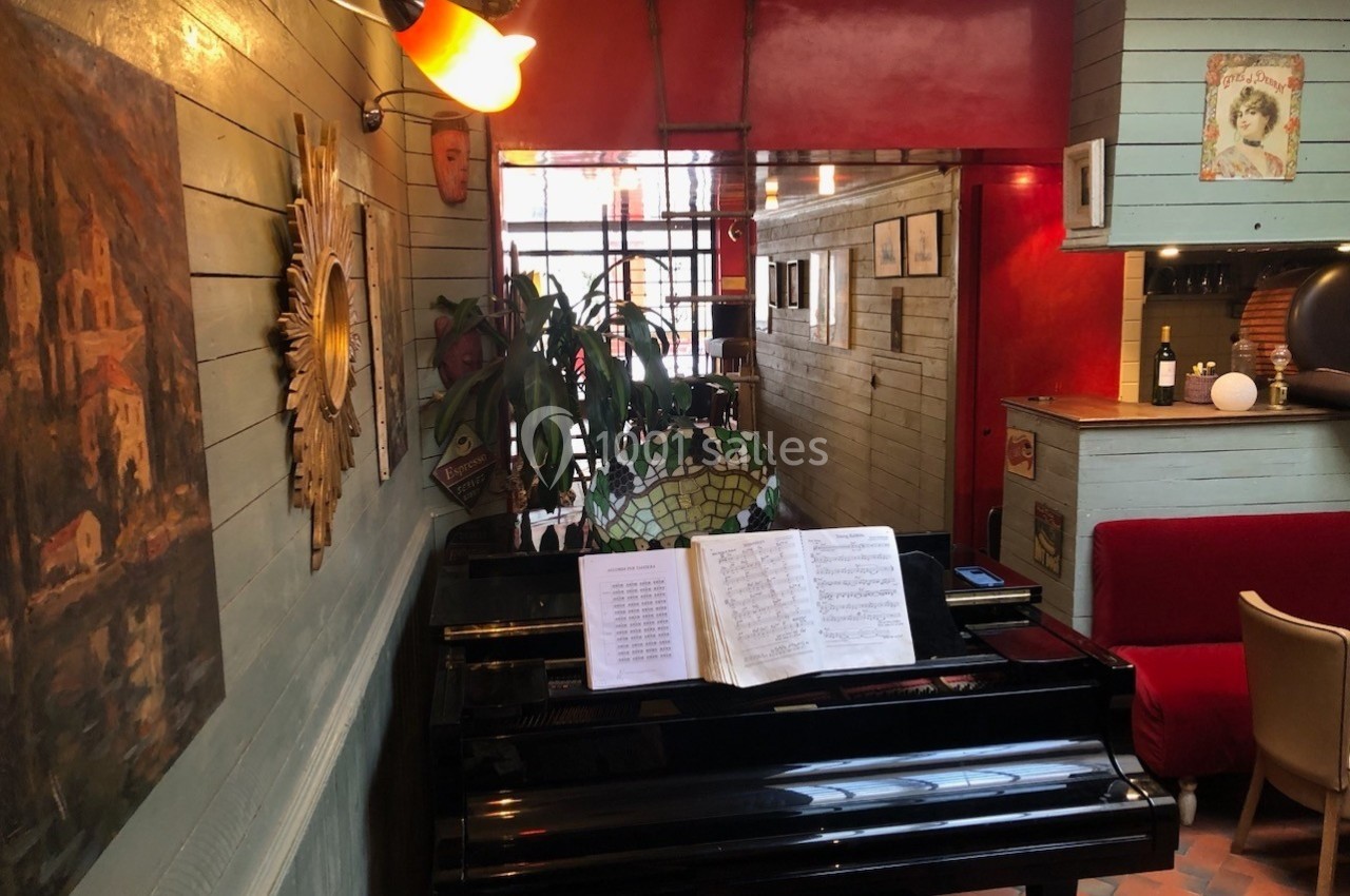 Piano noir avec une partition ouverte dans un intérieur chaleureux aux murs colorés et décorations artistiques.