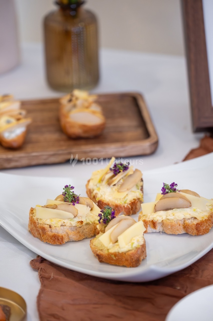 Tranches de pain garnies de fromage, champignons et herbes, présentées sur une assiette blanche.