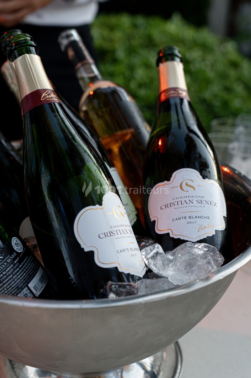 Bouteilles de champagne refroidies dans un seau rempli de glace, prêtes à être servies.