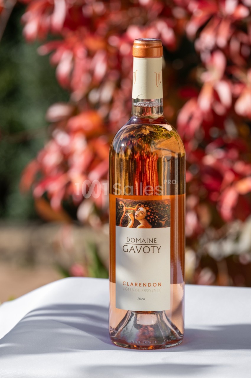 Bouteille de vin rosé Domaine Gavoty Clarendon 2024 posée sur une table, avec un fond de feuillage rougeoyant.