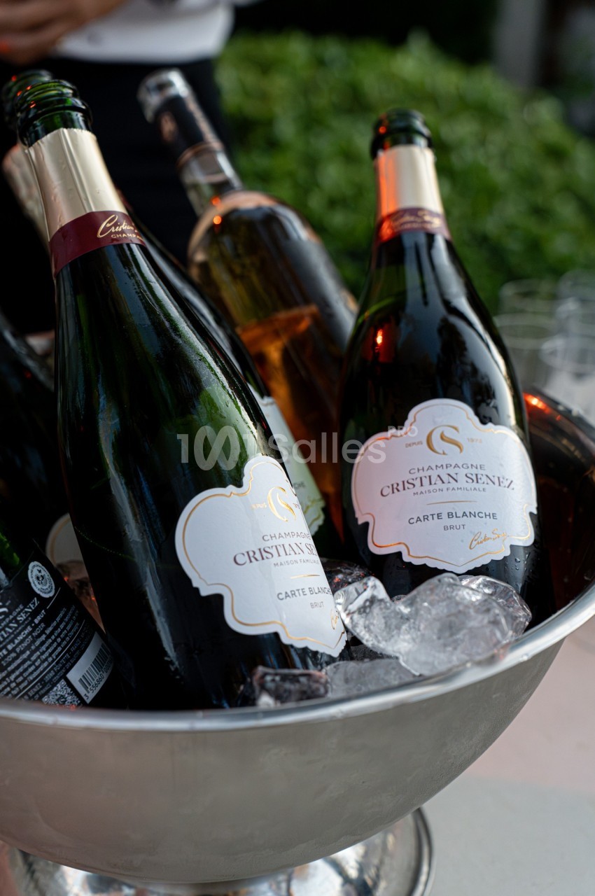 Bouteilles de champagne refroidies dans un seau rempli de glace, prêtes à être servies.