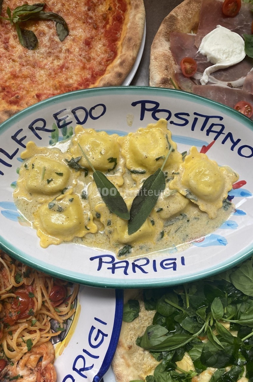 Assiette de raviolis sauce crémeuse garnie de feuilles de sauge, entourée de pizzas et de plats italiens.