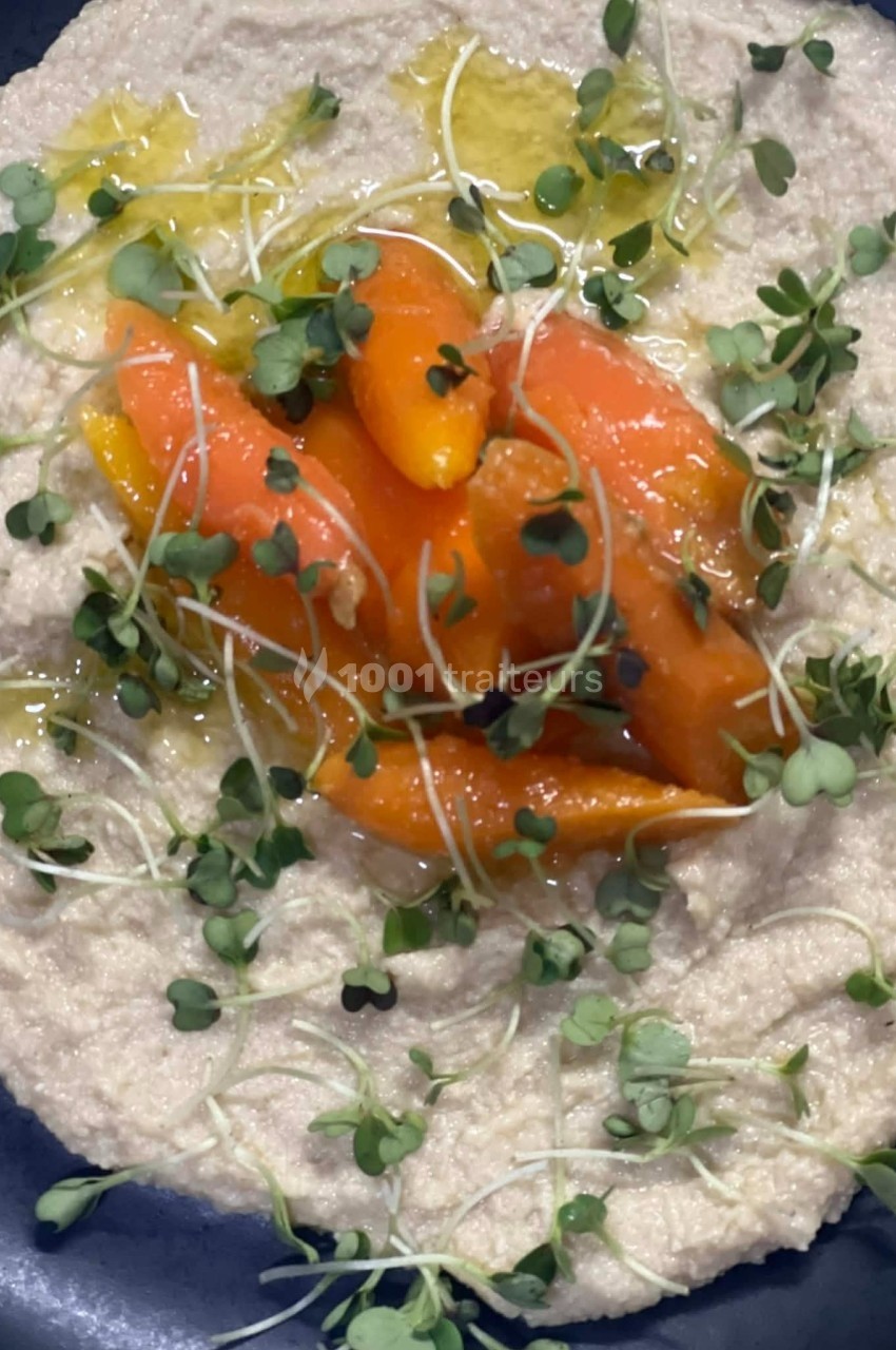 Purée crémeuse garnie de carottes rôties, pousses vertes et filet d'huile d'olive.