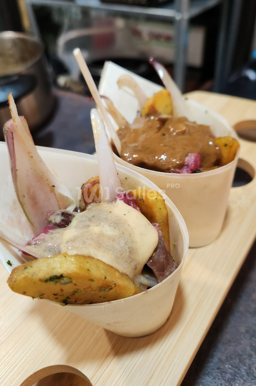 Deux portions de légumes rôtis avec sauce, présentées dans des coupelles en bois sur un plateau.