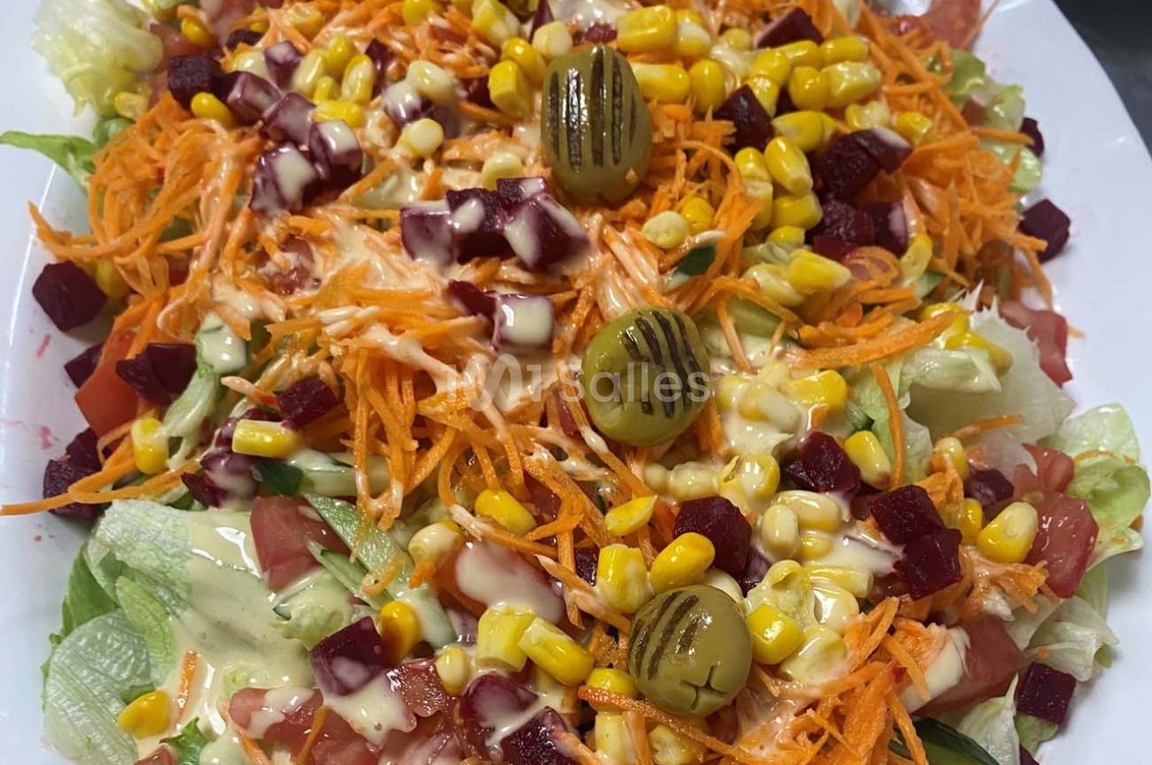 Salade composée avec laitue, carottes râpées, betteraves, maïs, tomates, olives grillées et sauce crémeuse.