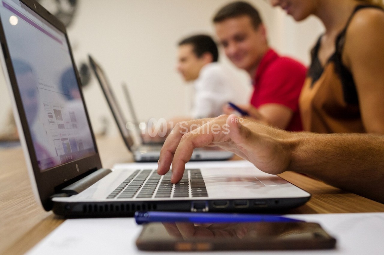 Personnes travaillant sur des ordinateurs portables dans un environnement de bureau collaboratif.