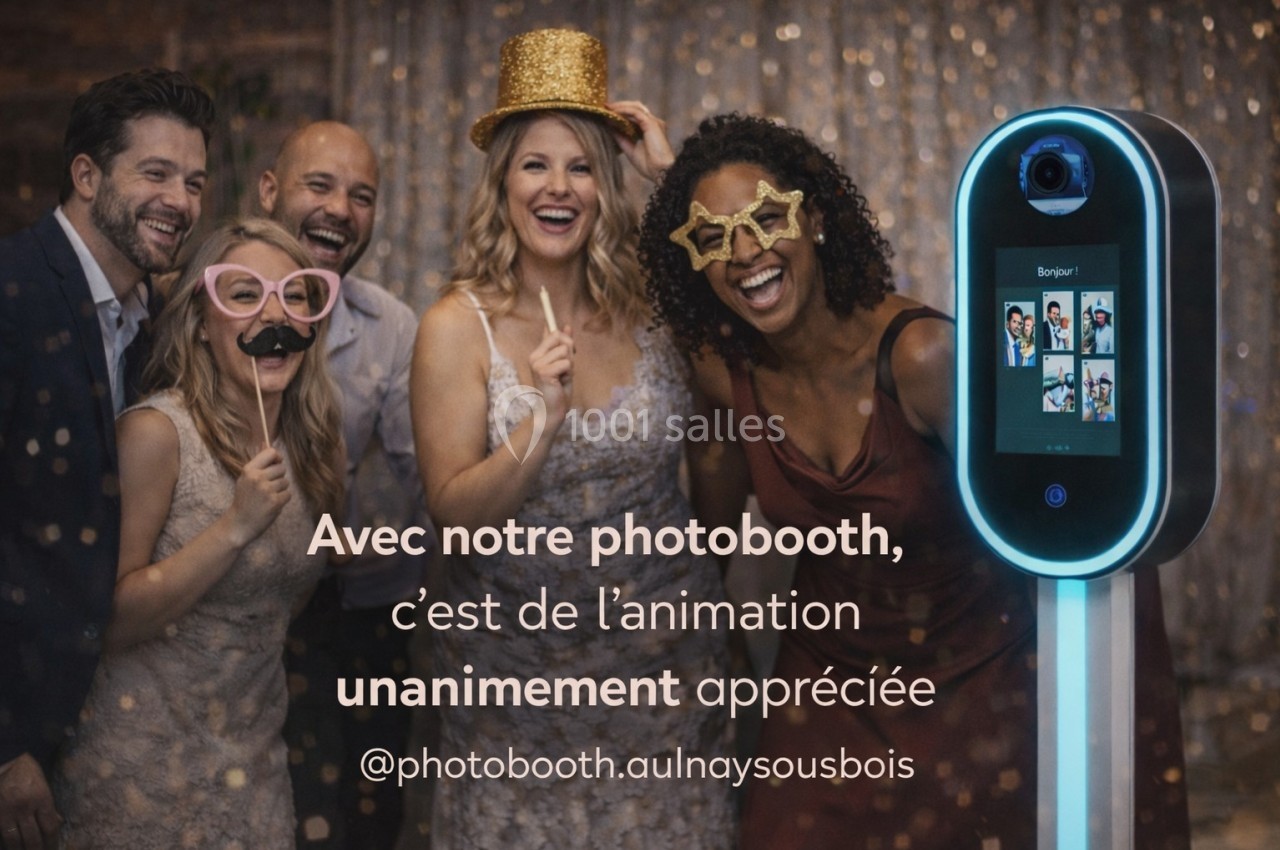 Un groupe d'adultes souriants pose avec des accessoires festifs devant un photobooth lumineux.
