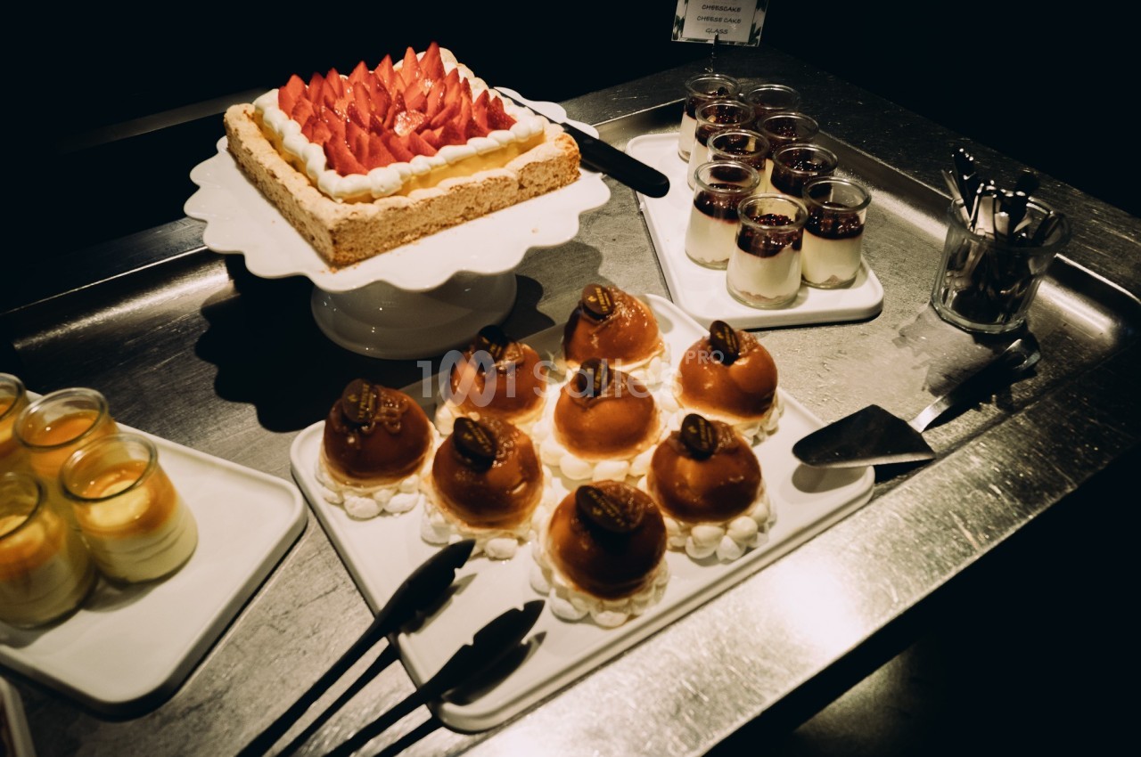 Plateau de desserts variés comprenant un gâteau aux fraises, des entremets individuels et des verrines.