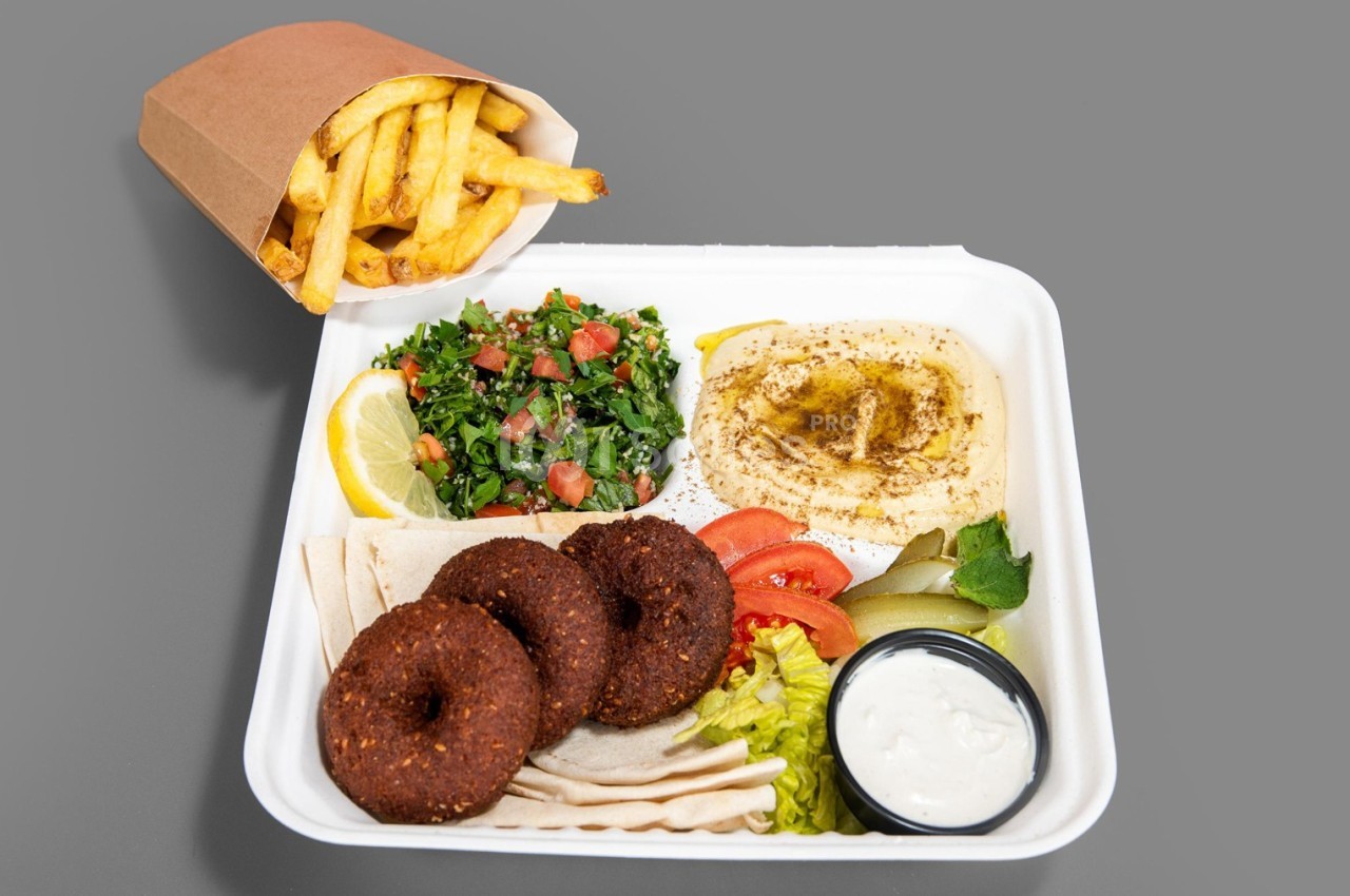 Assiette composée de falafels, houmous, taboulé, crudités, pain pita, sauce blanche, accompagnée de frites.