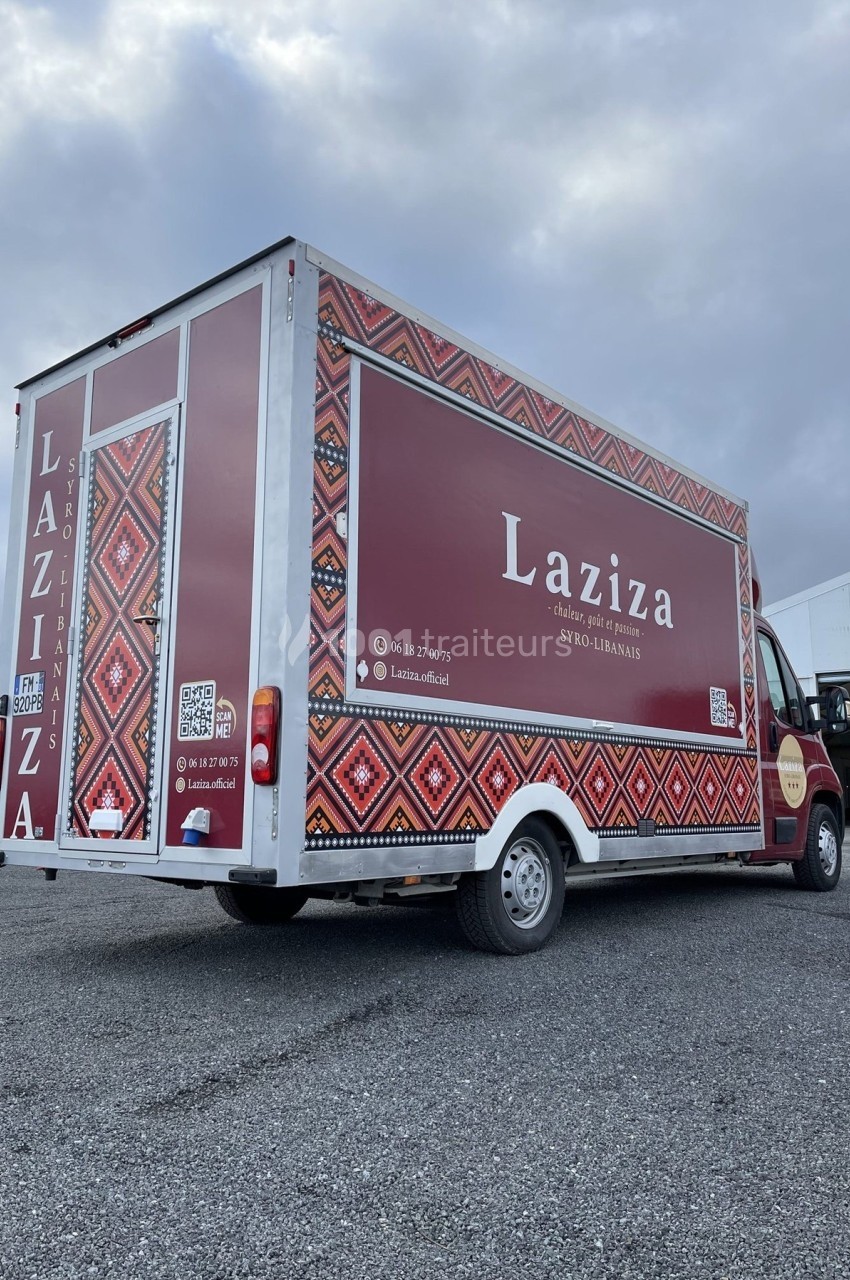 Camion de restauration syro-libanaise Laziza, rouge avec motifs traditionnels, stationné sur un parking.