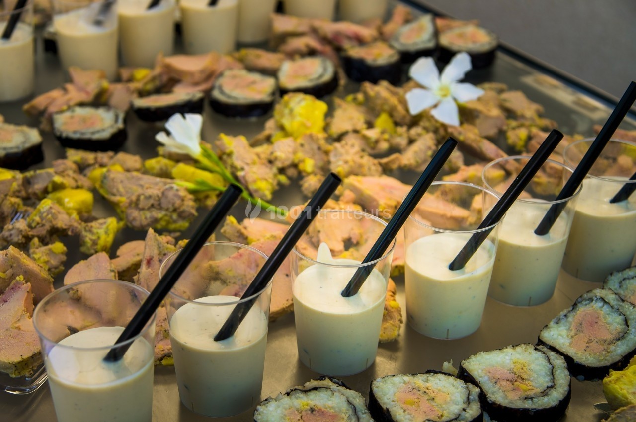 Assortiment de verrines, sushis et bouchées salées disposés sur un plateau de présentation.