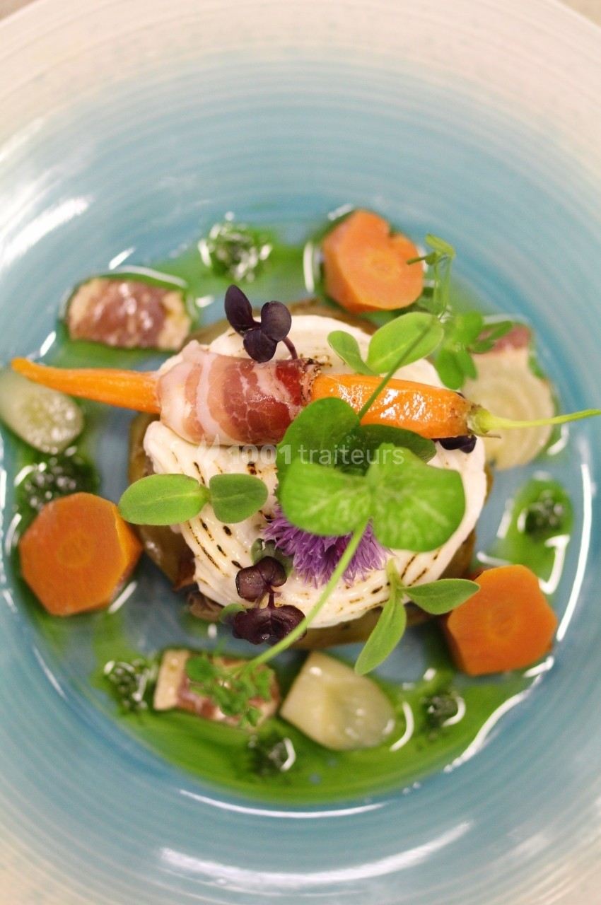 Assiette gastronomique avec légumes colorés, roulé de volaille au lard et herbes fraîches, présentée sur une sauce verte.