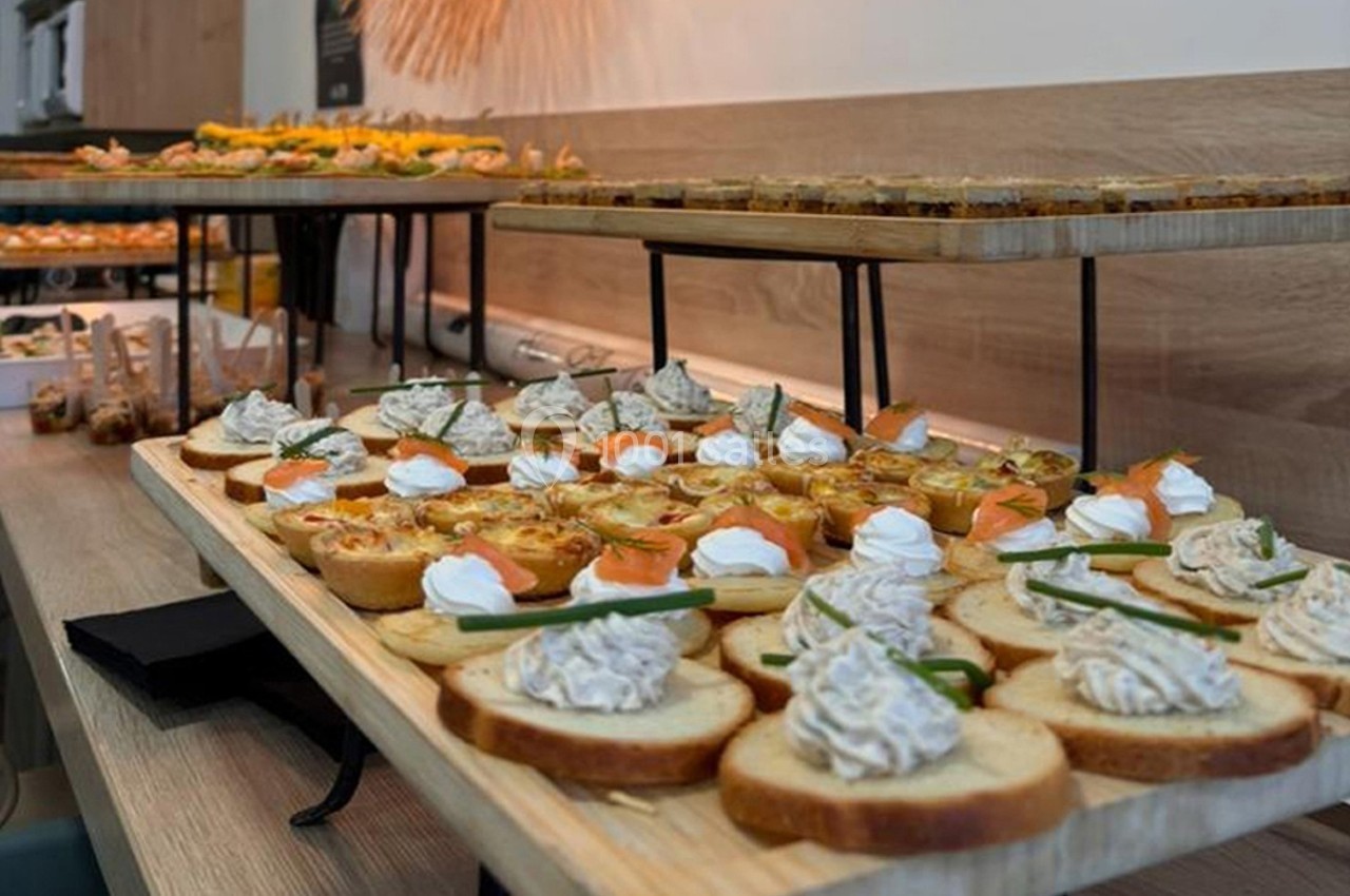 Plateaux de toasts variés garnis de mousse, saumon et crème, présentés sur une table en bois.