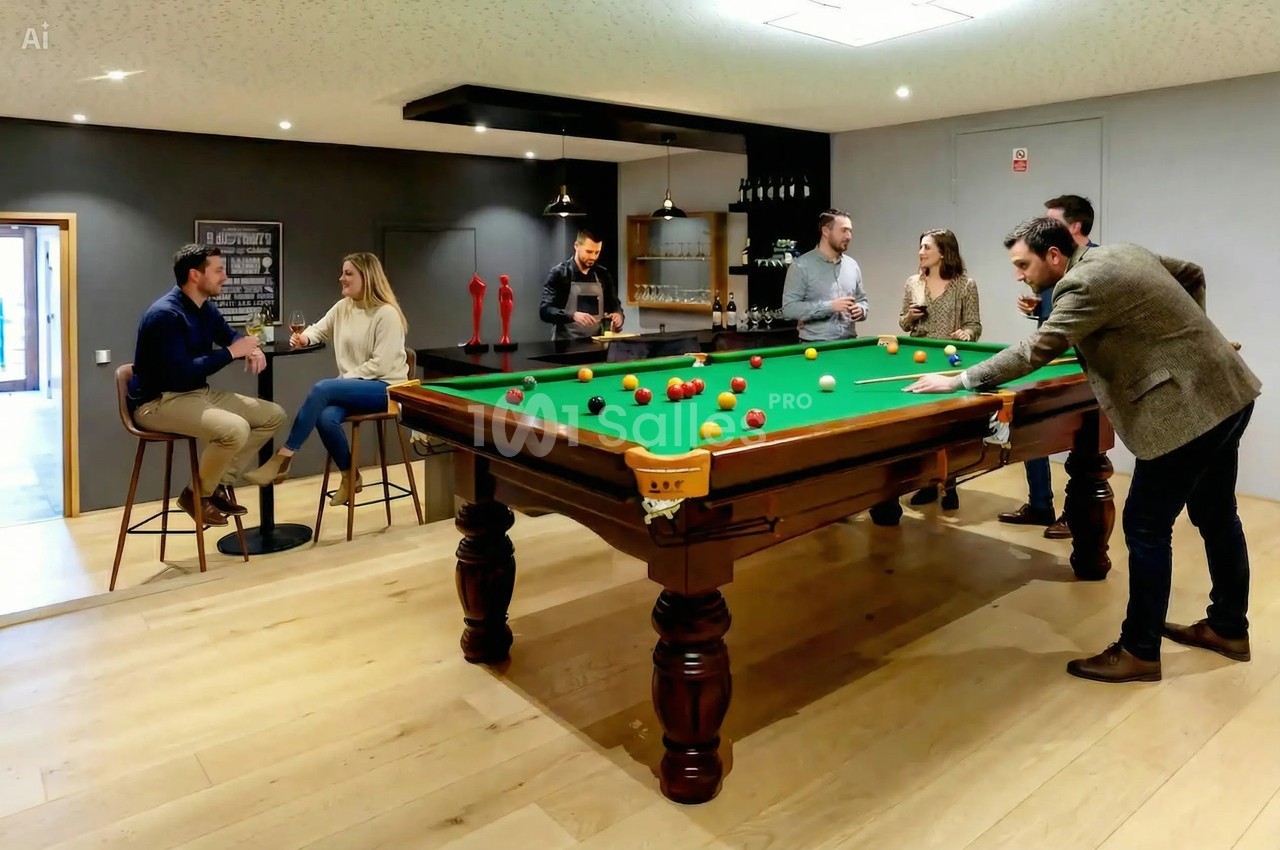 Des personnes discutent et jouent au billard dans une salle moderne avec un bar en arrière-plan.