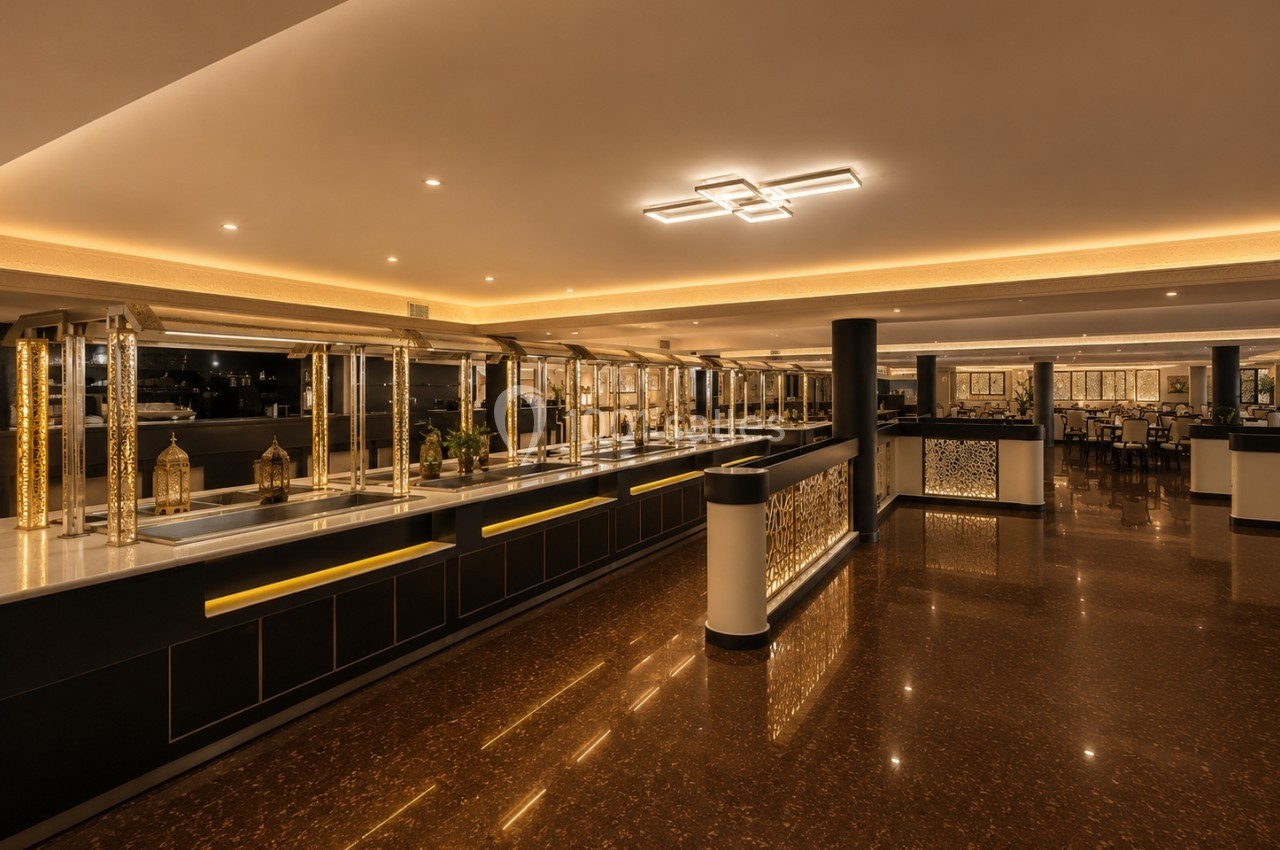 Buffet moderne avec comptoirs éclairés et décoration dorée dans une salle spacieuse au sol en marbre brun.