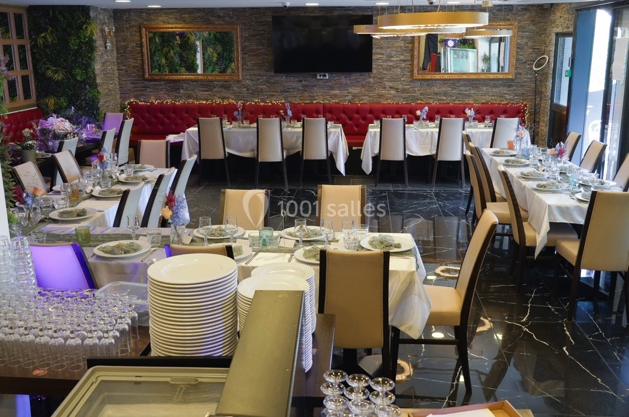 Salle de restaurant élégamment dressée avec des tables alignées, nappes blanches et chaises beige, prête pour un événement.
