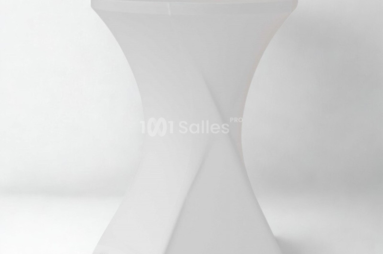 Table haute blanche avec housse ajustée, posée sur un fond uni clair.