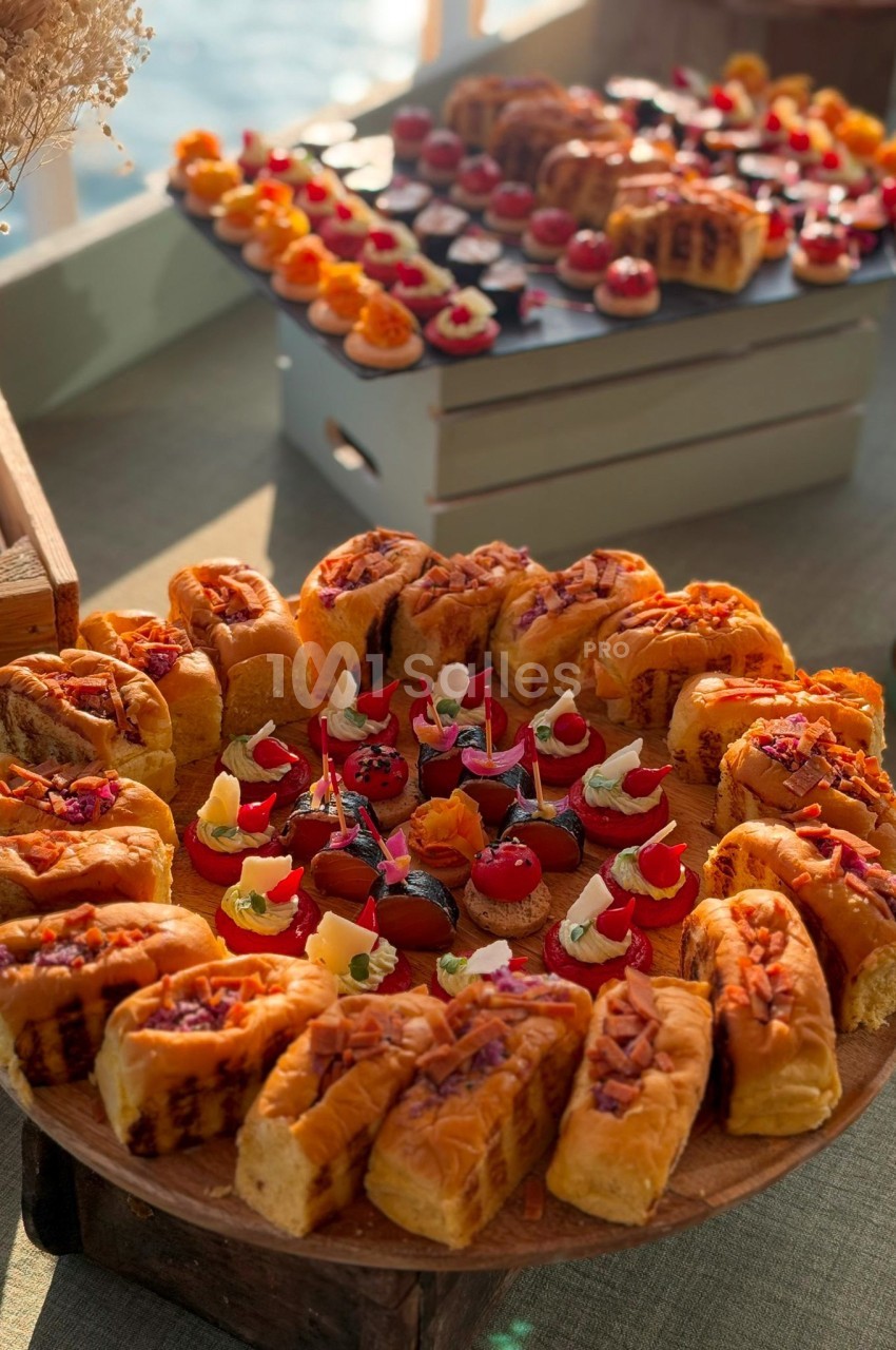 Plateau de viennoiseries et de petits desserts colorés présentés sur une table lors d'un buffet.