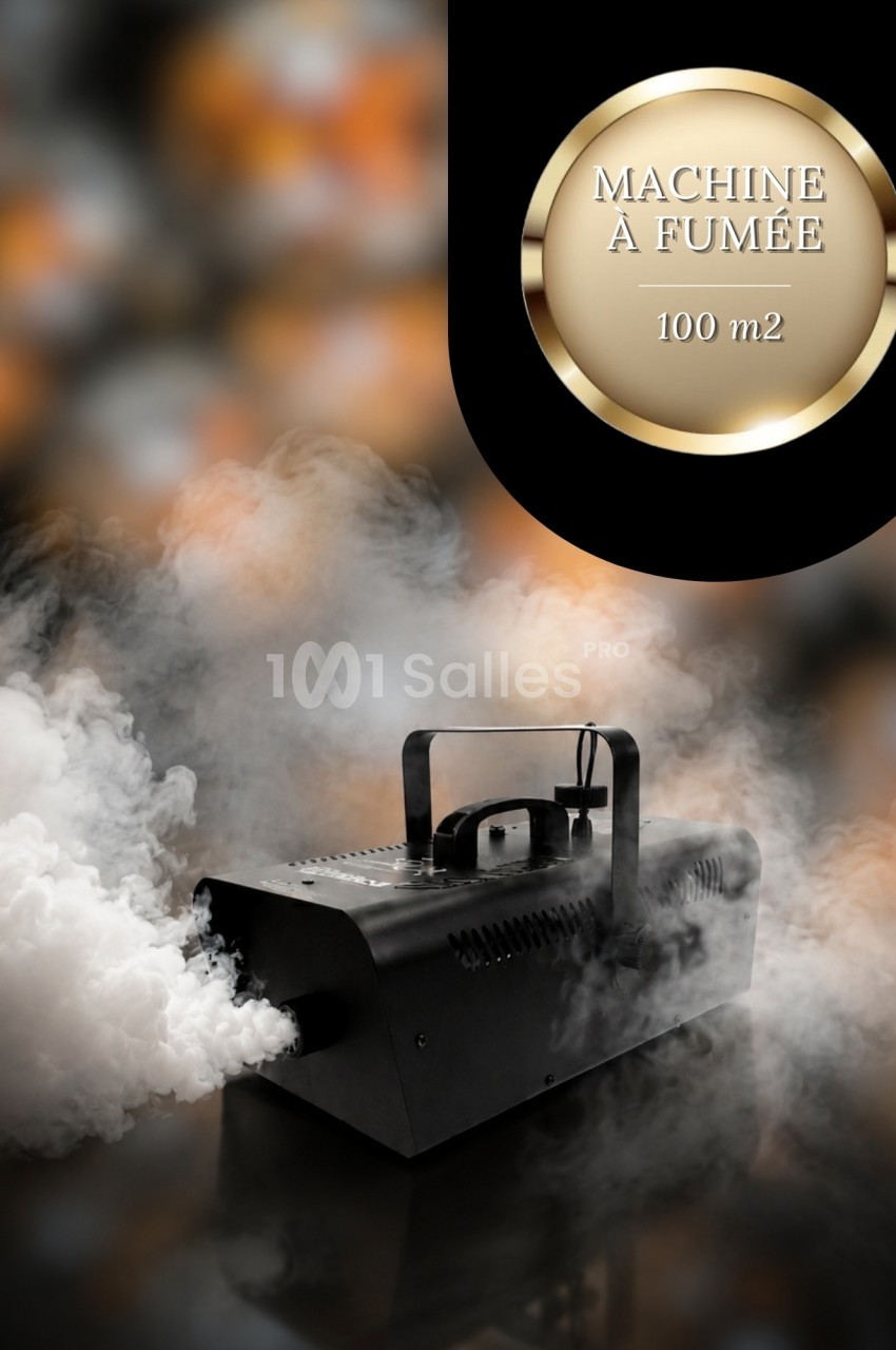 Machine à fumée noire en fonctionnement, dégageant un épais nuage blanc sur un fond sombre.