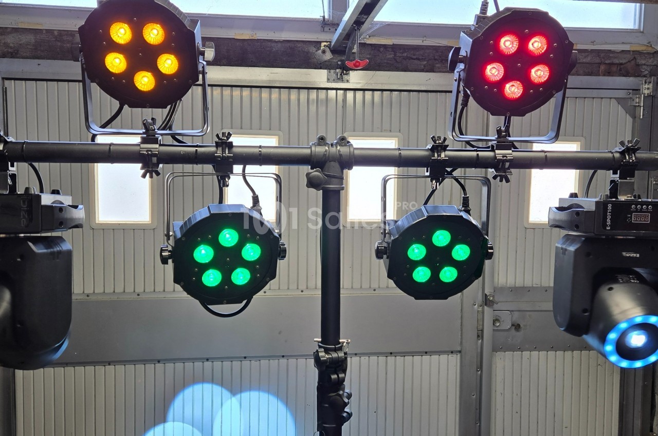 Projecteurs LED colorés et spots montés sur une structure métallique dans un espace de type garage.