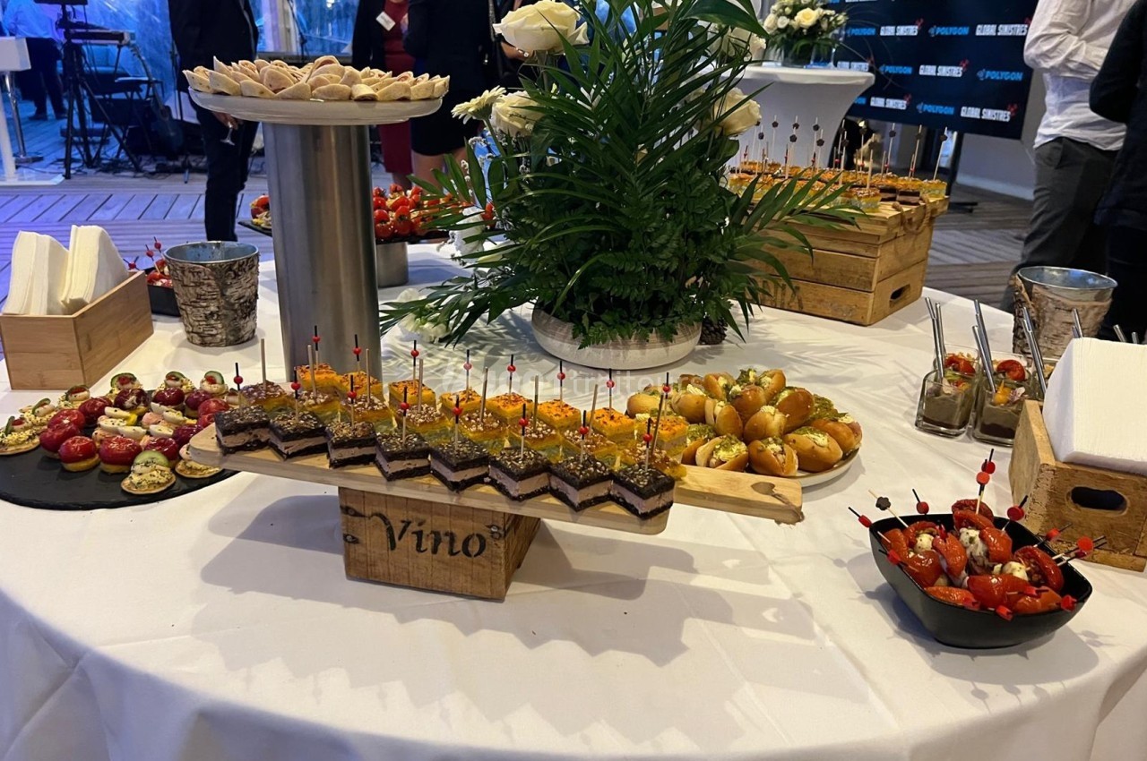 Table garnie de divers amuse-bouches, dont verrines, toasts et brochettes, lors d'un événement ou réception.