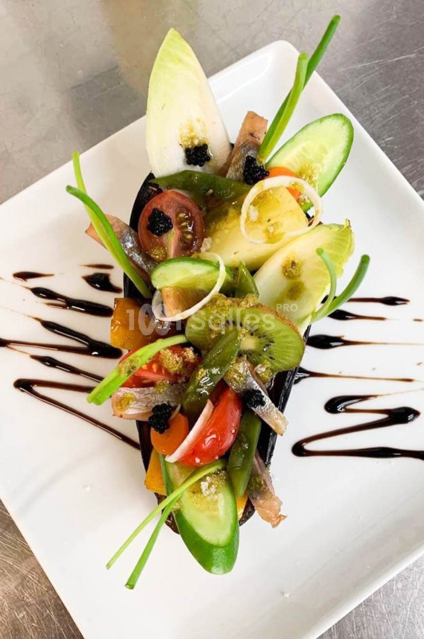 Assiette gastronomique composée de légumes frais, caviar végétal et sauce balsamique sur une présentation soignée.