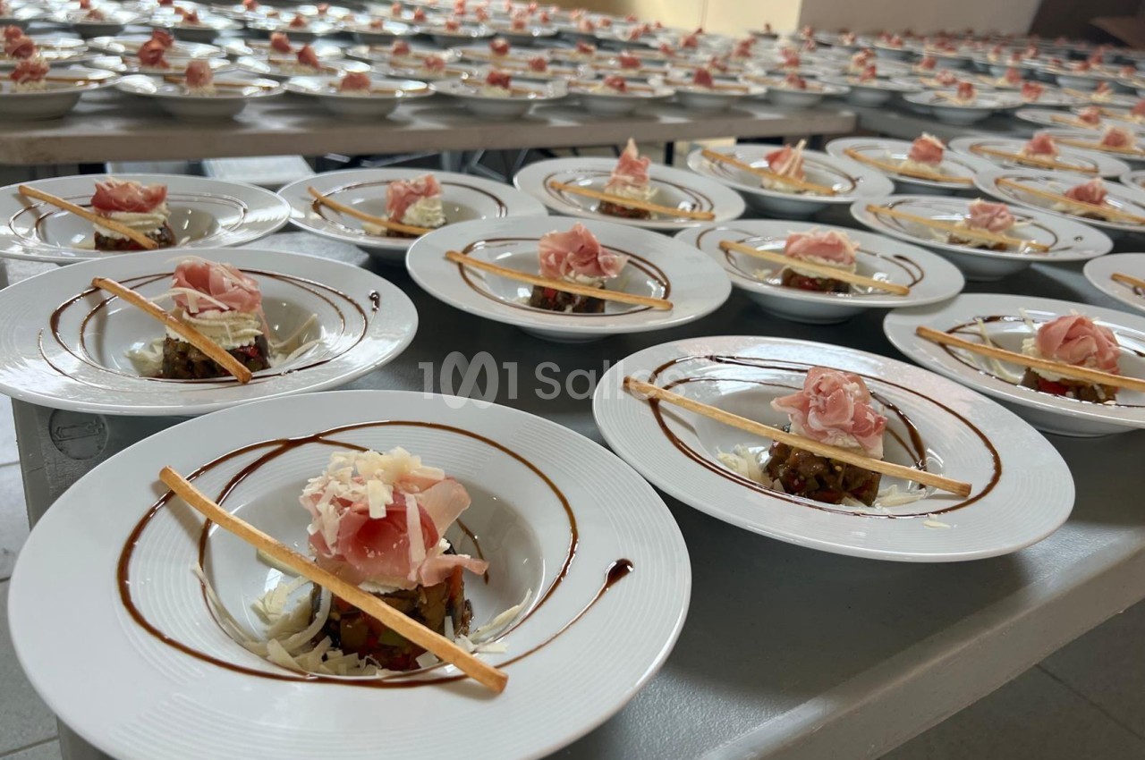 Assiettes dressées avec tartare de légumes, jambon cru, copeaux de fromage et filet de sauce balsamique.