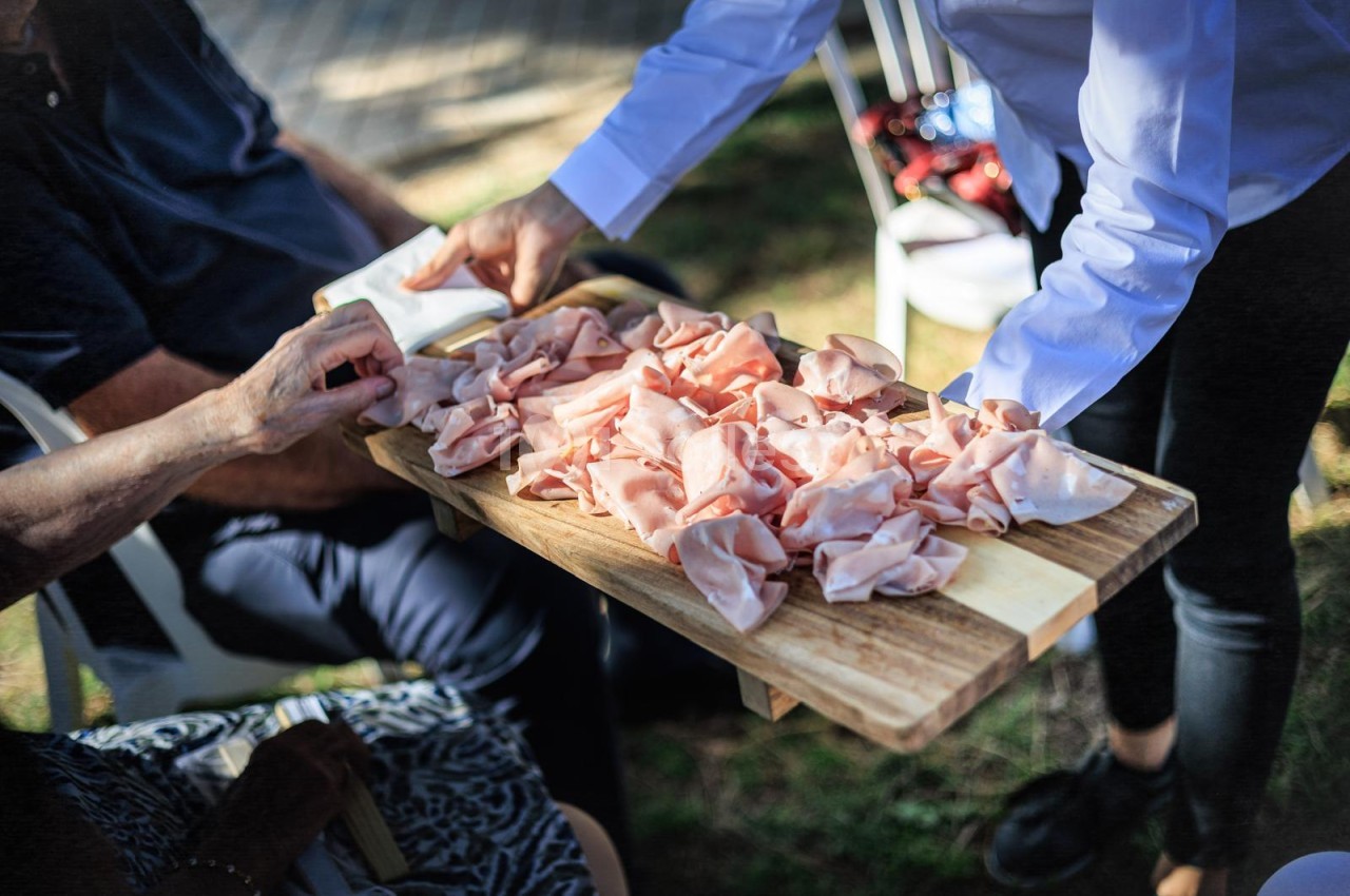 Plateau de charcuterie avec jambon cru servi en plein air lors d'un événement.