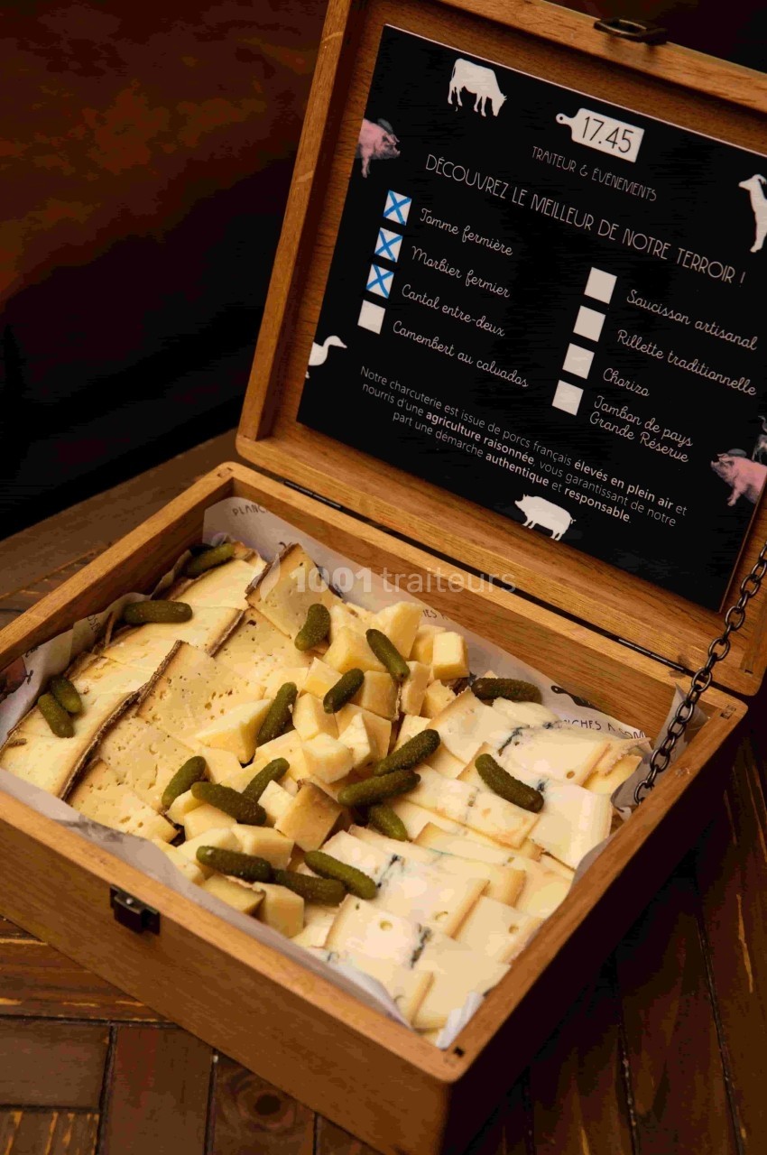 Coffret en bois ouvert contenant des fromages fermiers et cornichons, avec livret de présentation des produits.