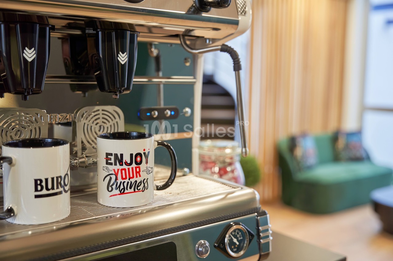 Machine à café professionnelle verte et inox avec deux tasses blanches sur le groupe de café.