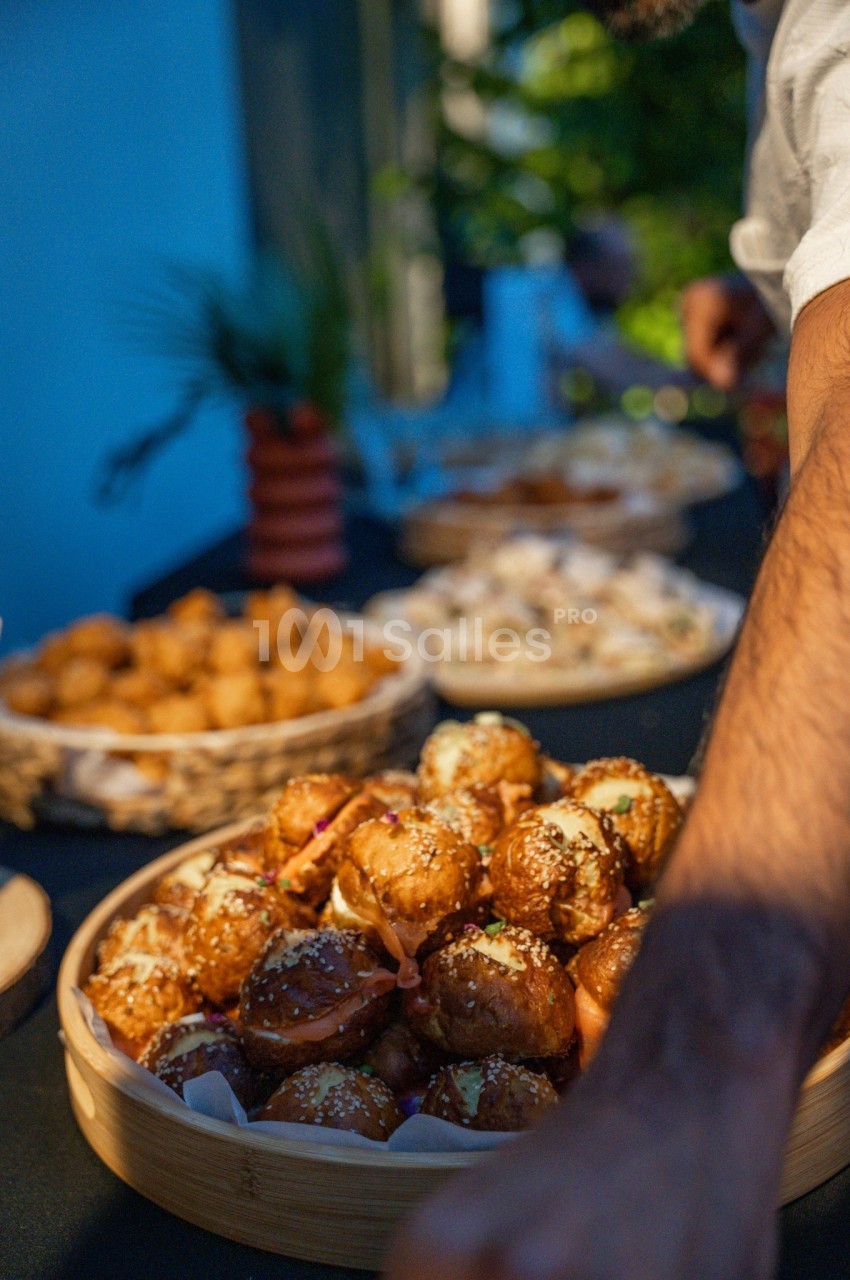 Boulettes dorées et brunes garnies d'herbes dans des assiettes en bois, service de repas en extérieur.