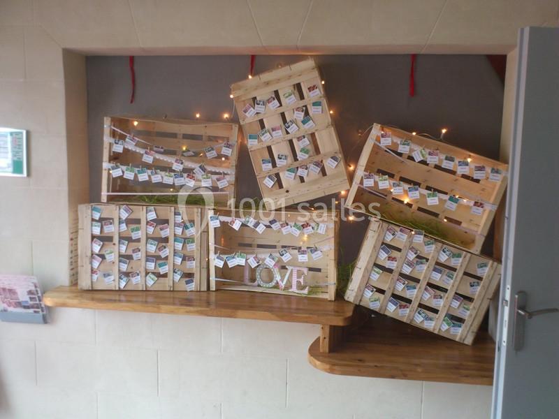Casiers en bois inclinés contenant des étiquettes colorées, décorés de guirlandes lumineuses et d'un mot ’LOVE’.