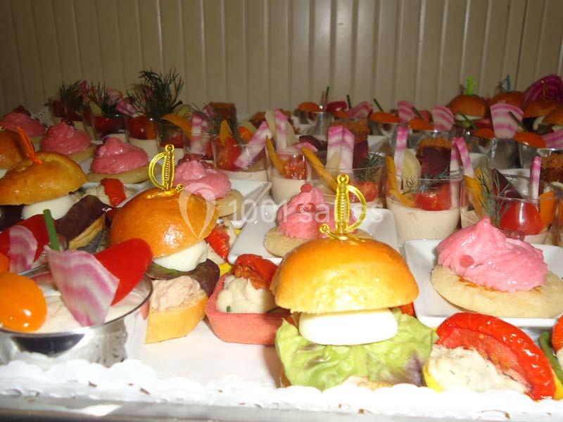 Plateau de bouchées apéritives variées comprenant mini-burgers, légumes, mousses colorées et garnitures décoratives.