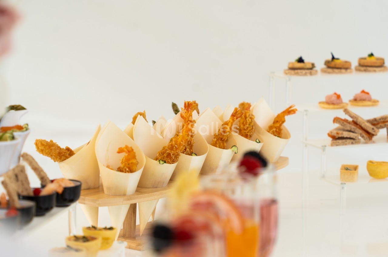 Assortiment de bouchées apéritives variées présentées sur des supports en bois et en verre.