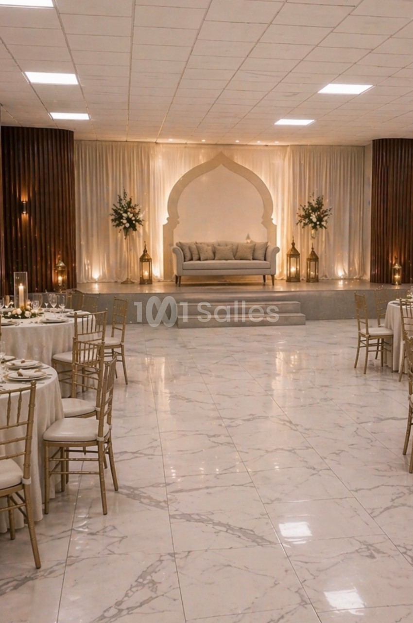 Salle de réception élégante avec tables dressées, chaises dorées et une estrade décorée d'un canapé et d'arches lumineuses.