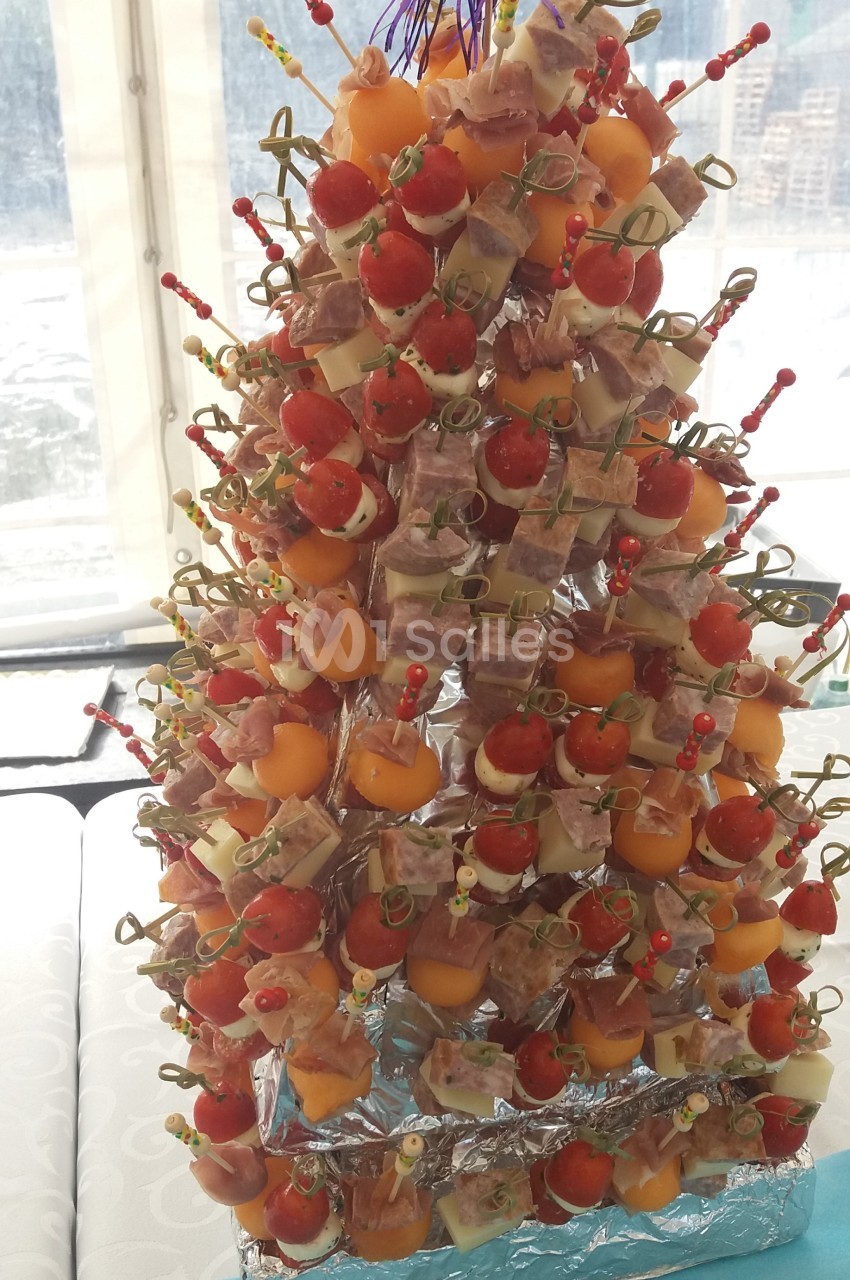Sapin comestible composé de brochettes apéritives avec tomates, melon, fromage et charcuterie.