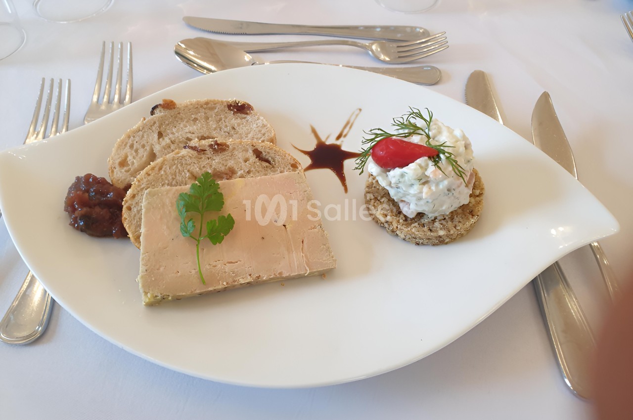 Assiette avec tranche de foie gras, pain aux fruits secs, chutney, et toast garni de crème et aneth.