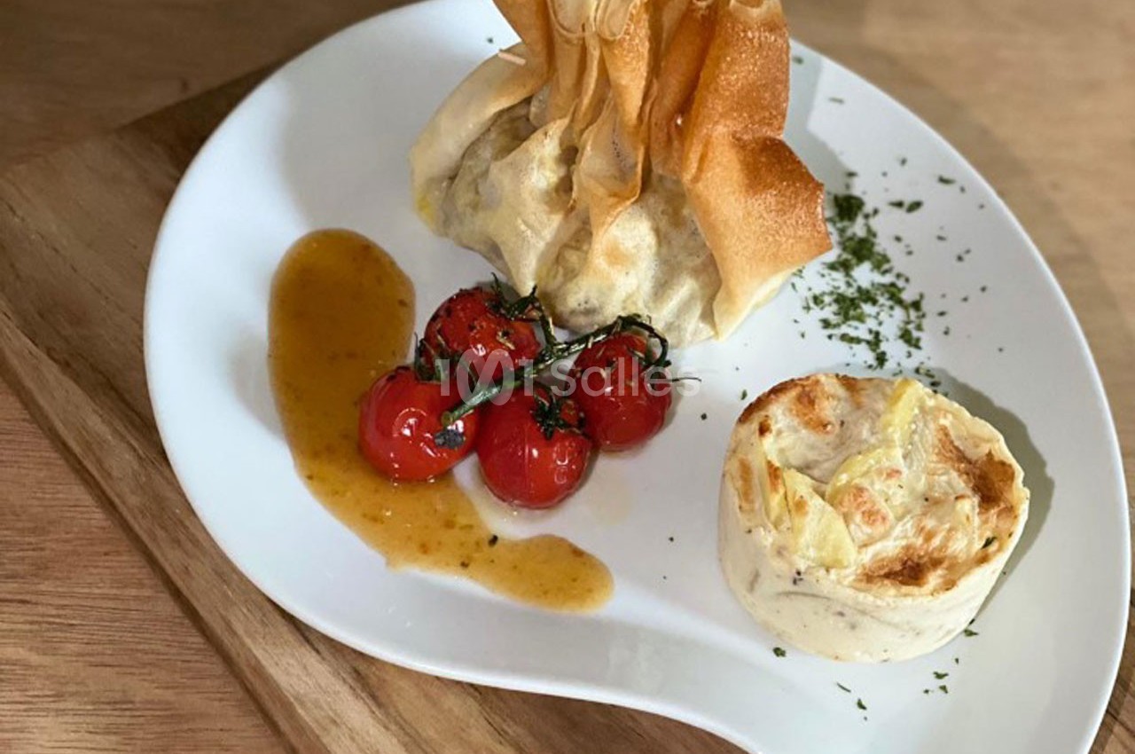 Assiette composée d'une aumônière croustillante, de tomates cerises rôties et d'un gratin individuel.