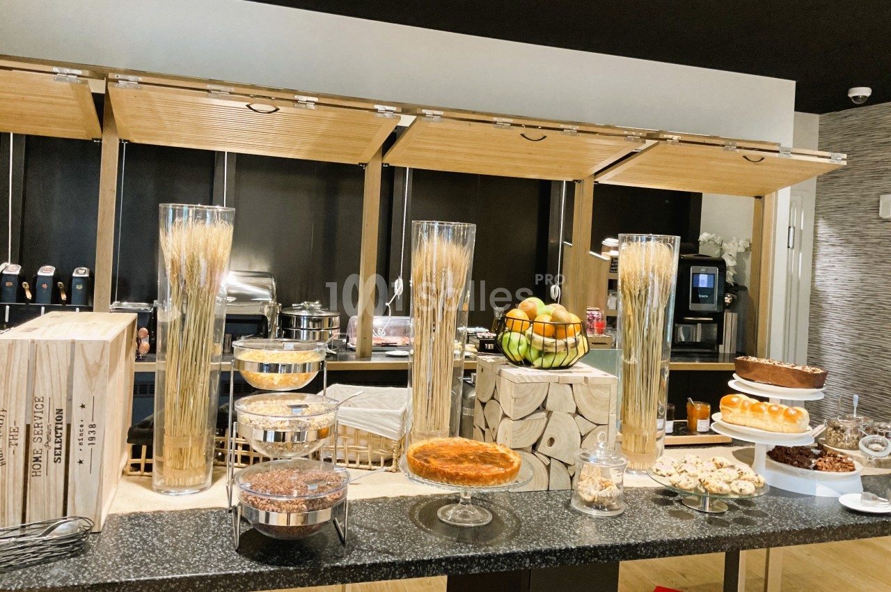 Buffet de desserts variés avec gâteaux, tartes, fruits et céréales, présenté sur un comptoir moderne.